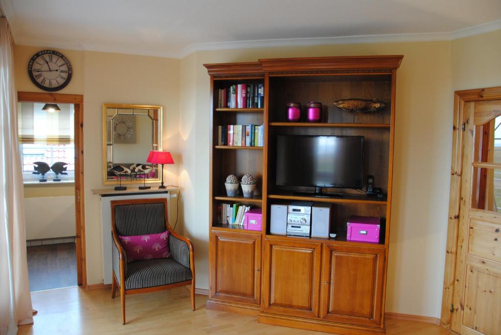 ein Wohnzimmer mit einem TV in einem Bücherregal in der Unterkunft Inselresidenz Wattenmeer - Wohnung 7 in Juist