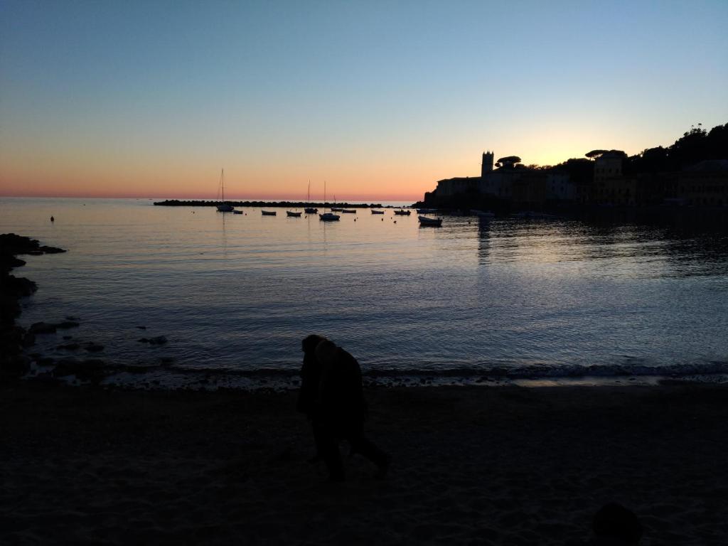 a person walking on the beach at sunset at Via della Chiusa 101 in Sestri Levante