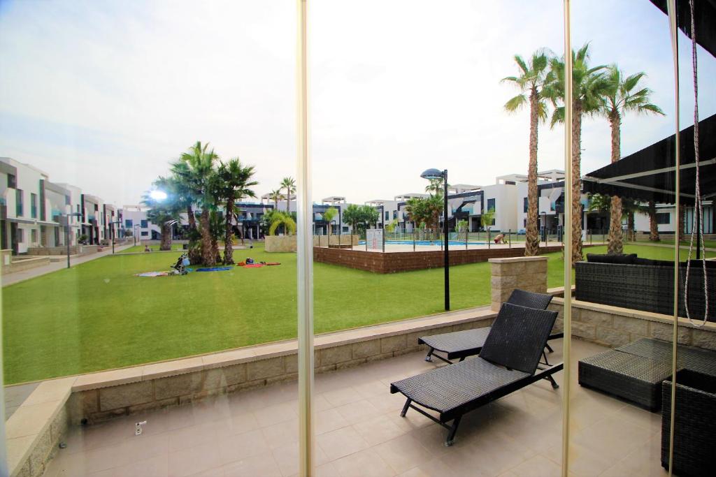 una sedia nera seduta su un balcone con parco di Oasis Beach Sonia a Orihuela Costa