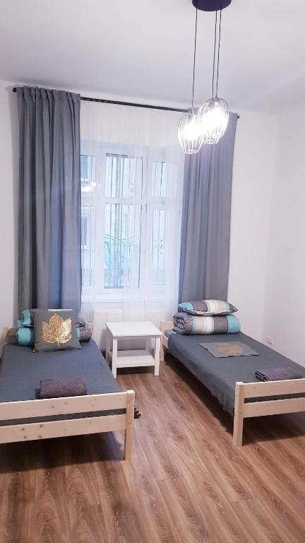 a bedroom with two beds and a chandelier at Guest Room RÓWNA in Kielce