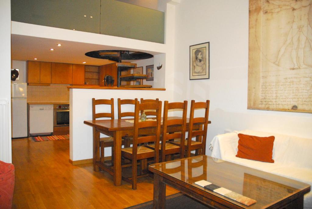 Luxurious Loft with Jacuzzi في مدينة هيراكيلون: مطبخ وغرفة معيشة مع طاولة وكراسي