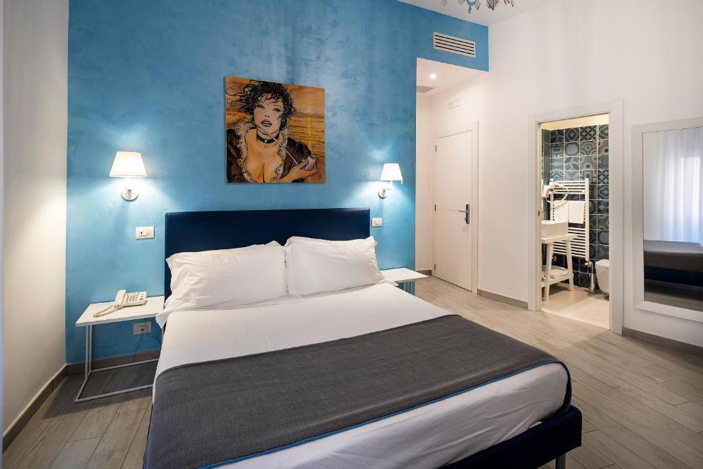 una camera con un grande letto e una parete blu di IstayinToledo Luxury Guest House a Napoli
