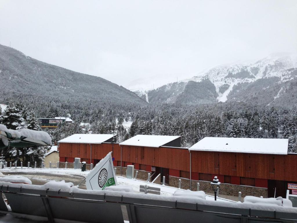 a building with snow on it in the mountains at Hotel Amoretes in La Molina