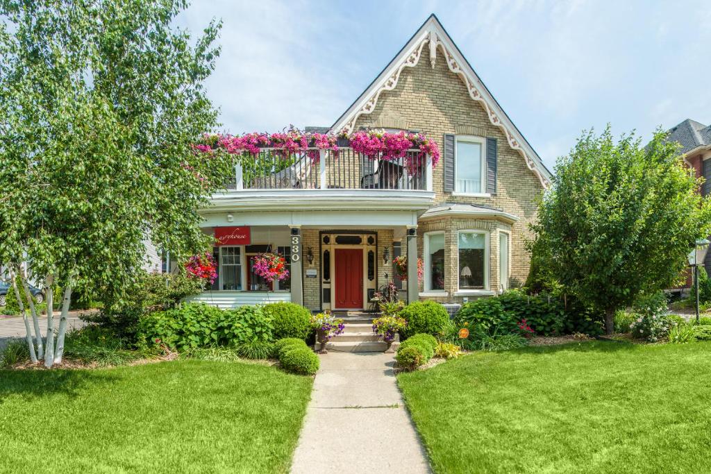 une maison avec un balcon orné de fleurs roses dans l'établissement Avery House B&B, à Stratford