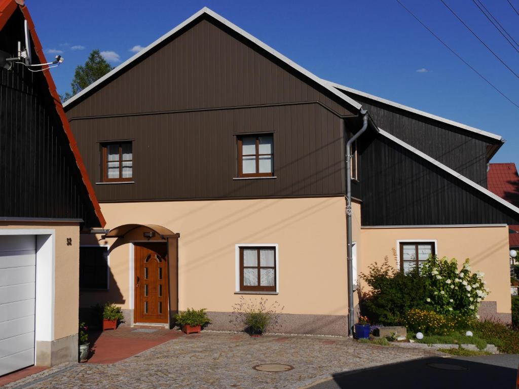 a house with a black roof and a garage at Bergblick in Saupsdorf