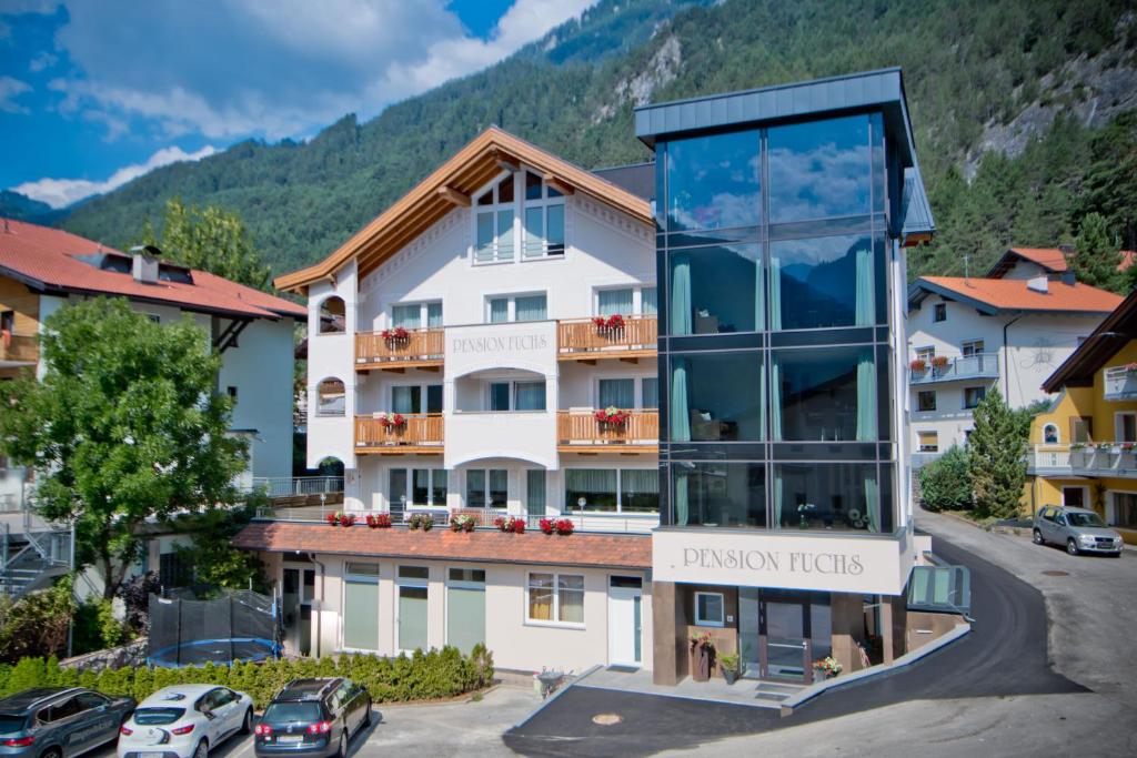 a large white building with a sign that reads passion tours at Pension Fuchs in Pfunds