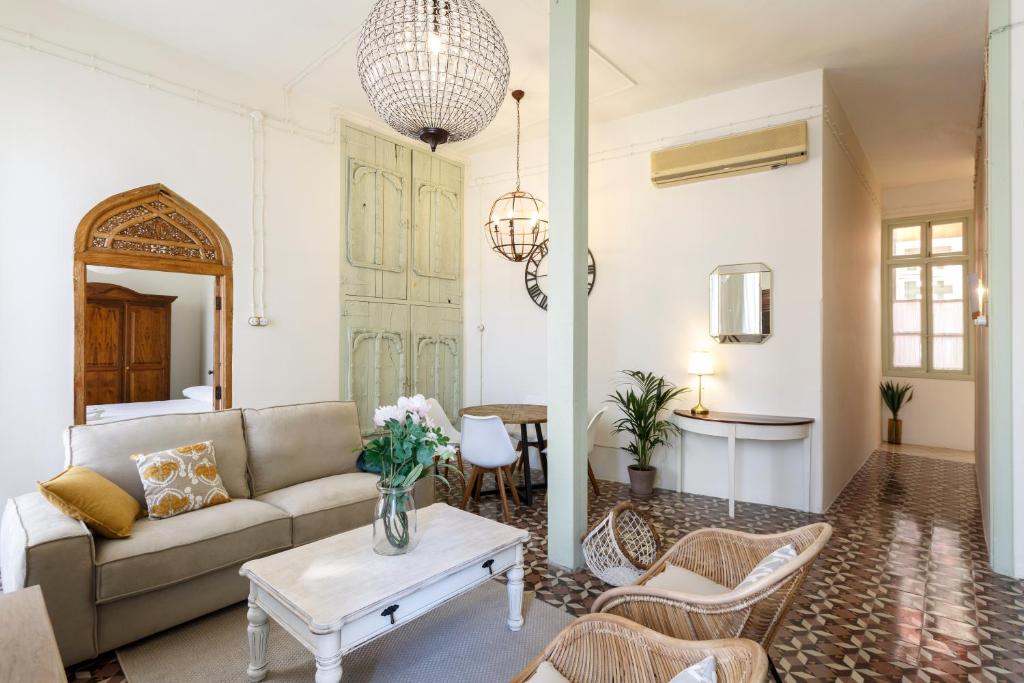 ein Wohnzimmer mit einem Sofa und einem Tisch in der Unterkunft Teatro Suites Málaga in Málaga