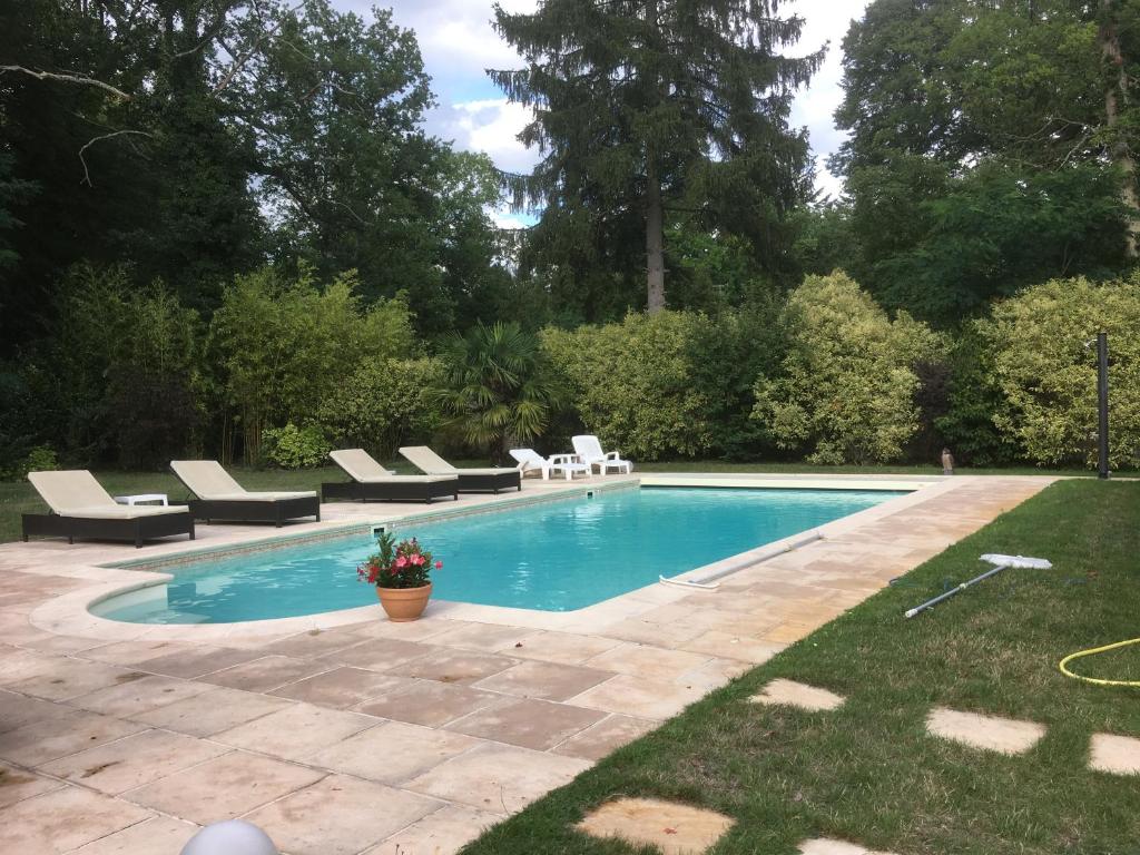 a swimming pool with lounge chairs in a yard at Les Enclos Bed and Breakfast à 4 mn de Chantilly in Lamorlaye
