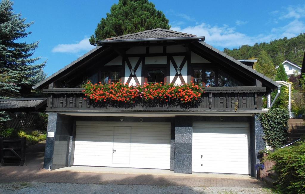 two garage doors in front of a house with flowers at Ferienhaus und Privatvermietung Andrea Giesecke in Meiningen