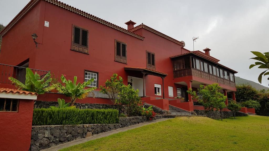 TeguesteにあるVilla Alisの緑の庭のある大きな赤い建物