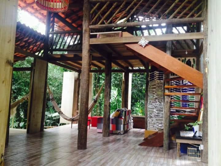 a room with a large wooden structure with a roof at Casa Cabana Ecológica in Boicucanga