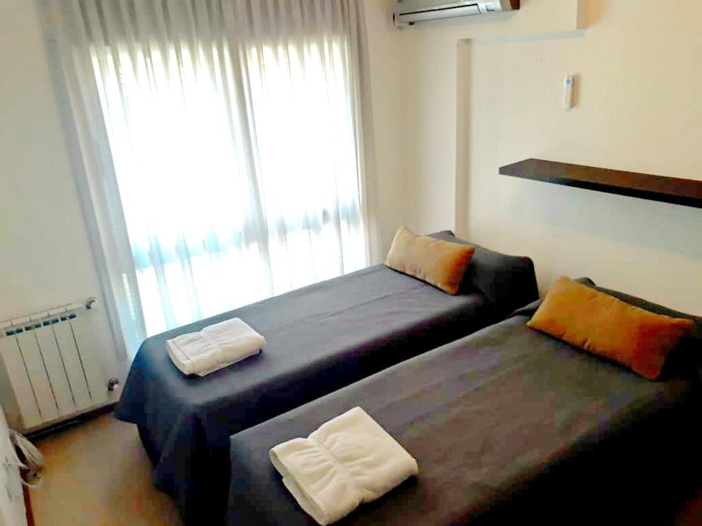 2 camas en una habitación pequeña con ventana en Apartamento 2 Dormitorios - Córdoba - Norten en Córdoba
