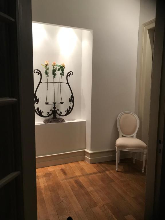 een kamer met een vaas met bloemen en een stoel bij 2 Boulevard de Nancy in Straatsburg