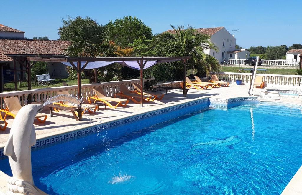 a swimming pool with chairs and a dolphin in the water at La Caleche in Bégadan