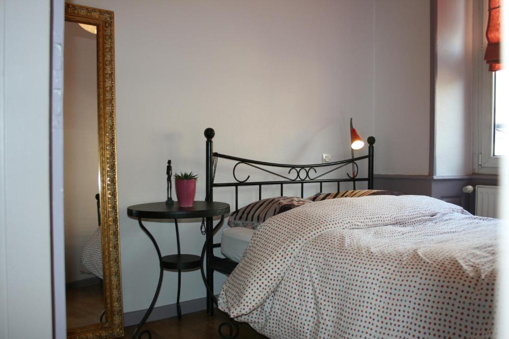 una camera con letto, specchio e tavolo di Il Piano Nobile a Colmar