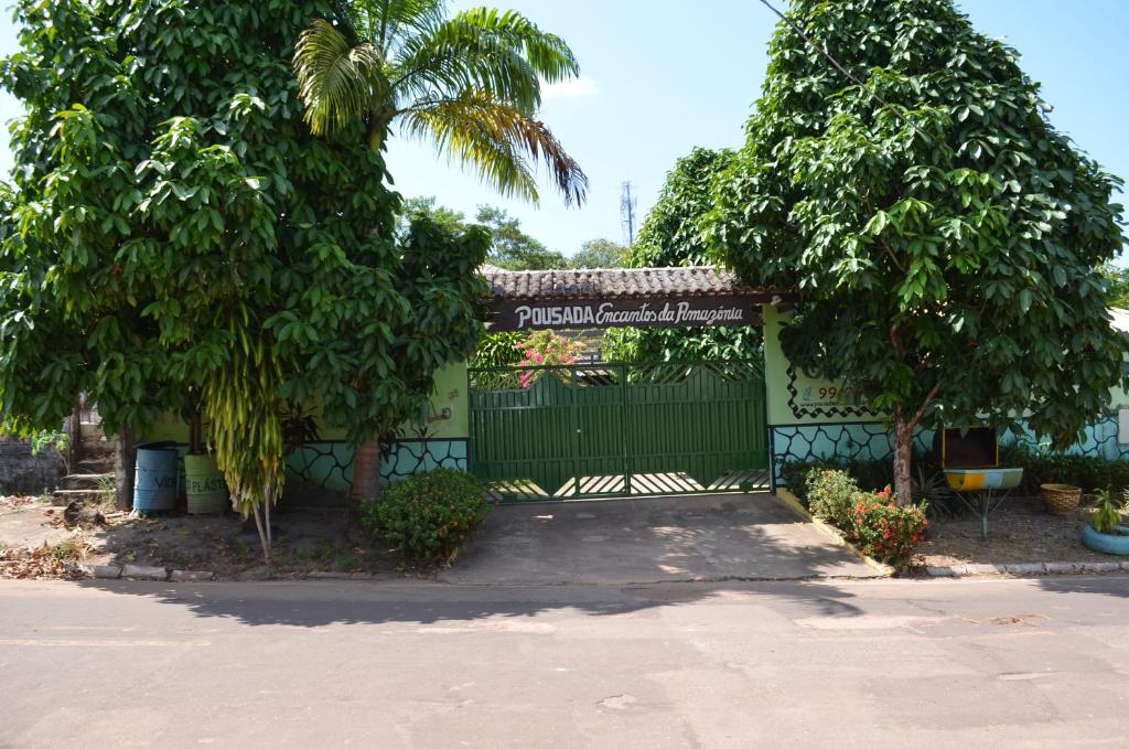 a building with a gate and trees in front of it at Pousada Encantos da Amazônia in Alter do Chao