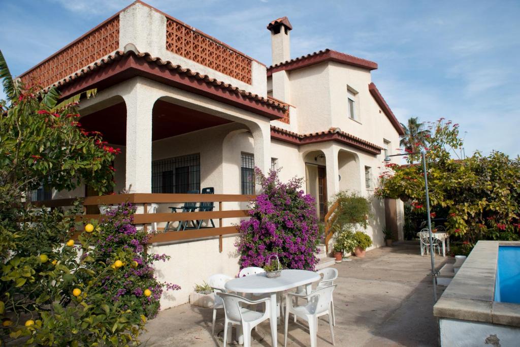 Una casa con una mesa y sillas delante de ella. en Villa Boverals, en Vinarós