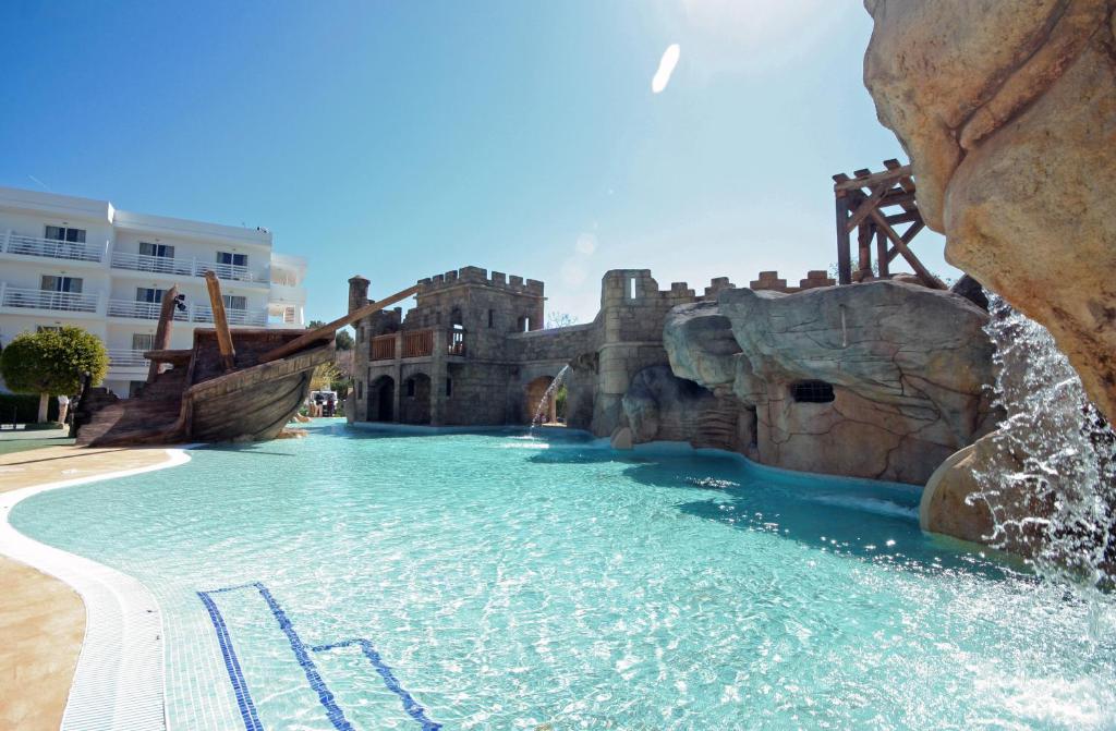 a swimming pool with a waterfall in the middle of it at Pirates Village in Santa Ponsa