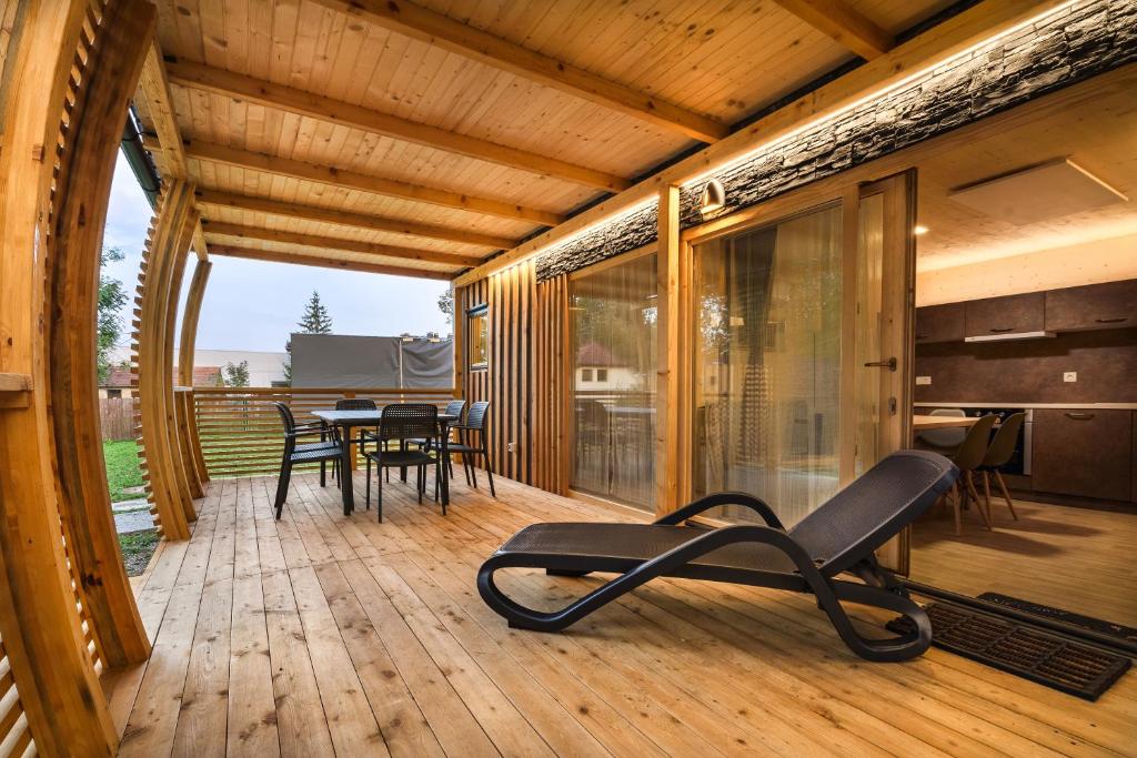 una terrazza in legno con una sedia e un tavolo di Pearl of Sava Wild Waters a Lubiana