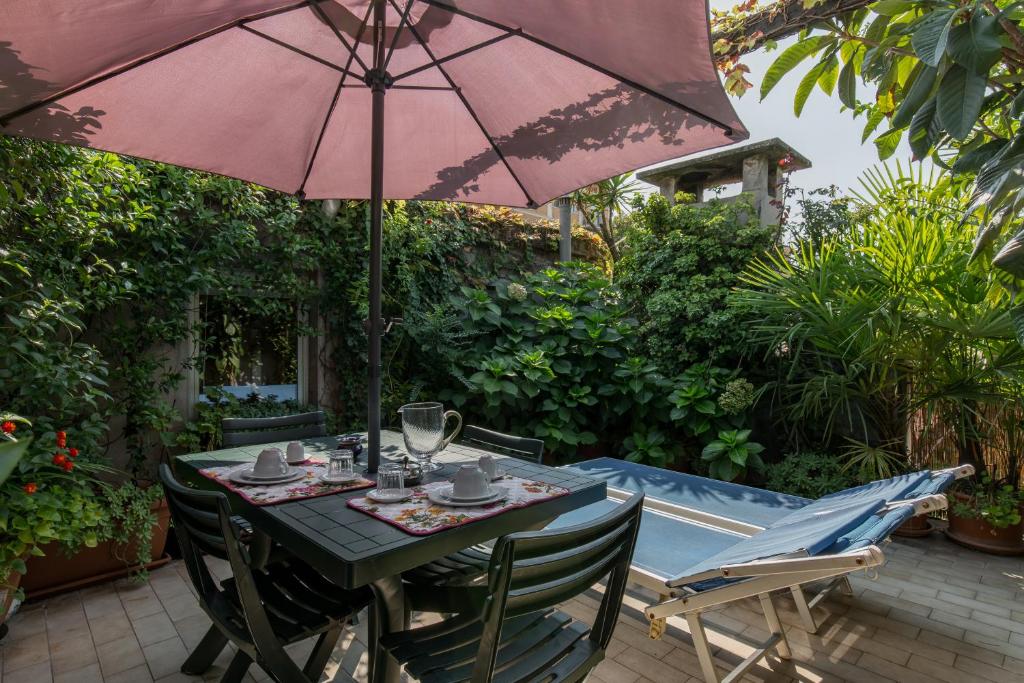 einen Tisch und Stühle unter einem Sonnenschirm auf einer Terrasse in der Unterkunft Gheller Apartment in Verona