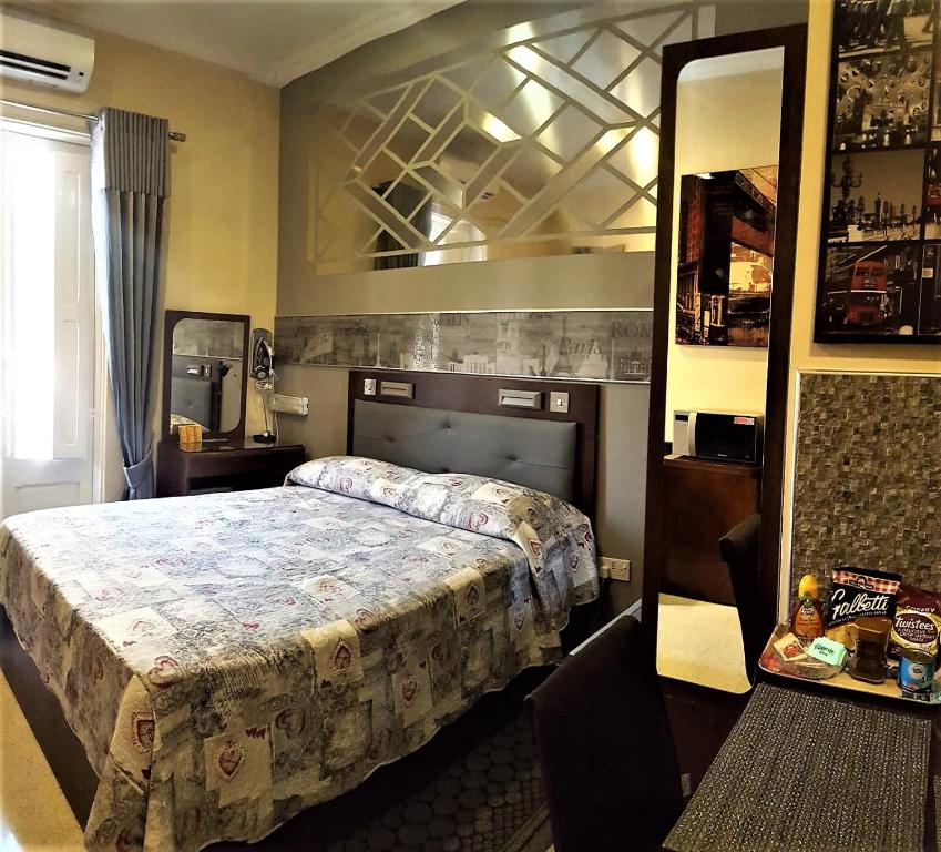 a bedroom with a bed and a large mirror at TAFERNINE STUDIO in the heart of Mosta in Mosta
