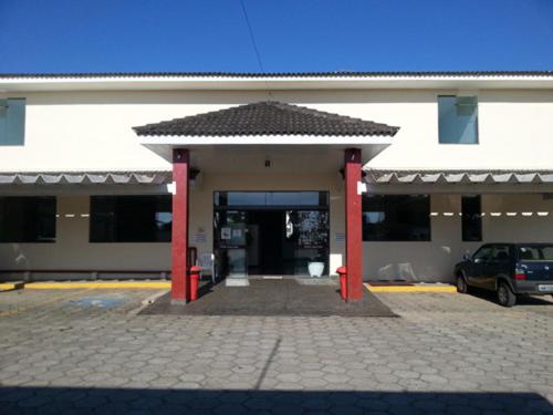 a building with red columns in a parking lot at Hotel Gran Valle in Registro