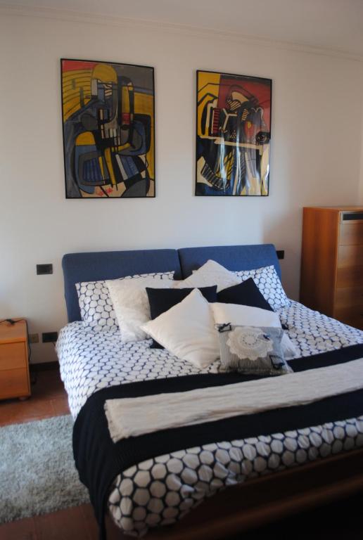 ein Bett in einem Schlafzimmer mit Gemälden an der Wand in der Unterkunft La Maison d'Alizè in Lecco