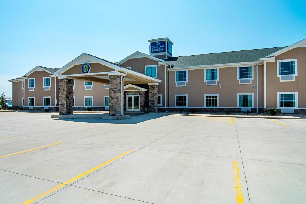 an empty parking lot in front of a building at Cobblestone Hotel & Suites - Paxton in Paxton