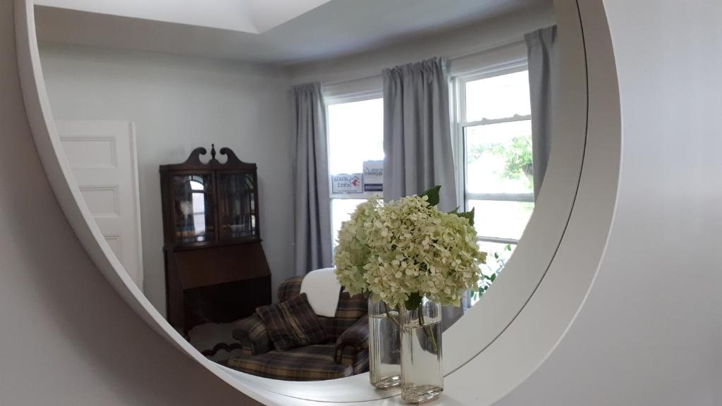 a mirror in a living room with a vase of flowers at Hillside Landing B&B in Digby