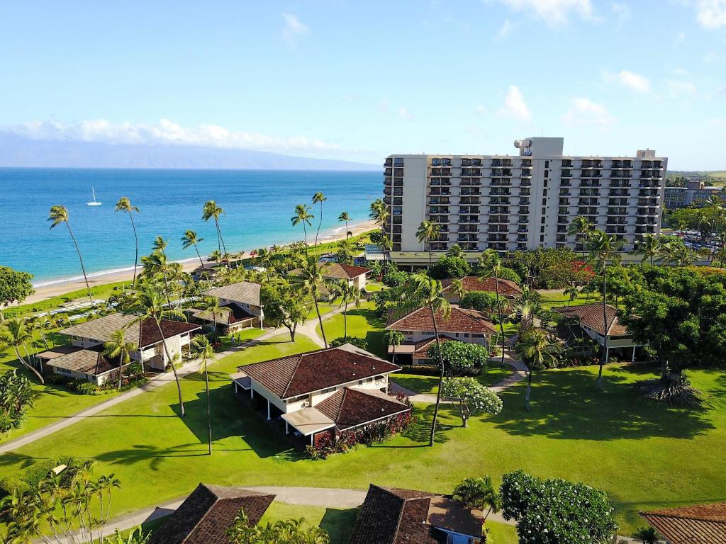 
a beach scene with a large building and palm trees at Royal Lahaina Resort in Lahaina
