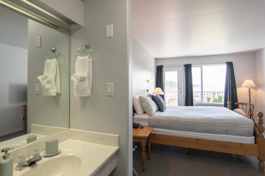 a bedroom with a bed and a sink and a mirror at Harbour House Hotel in Ganges