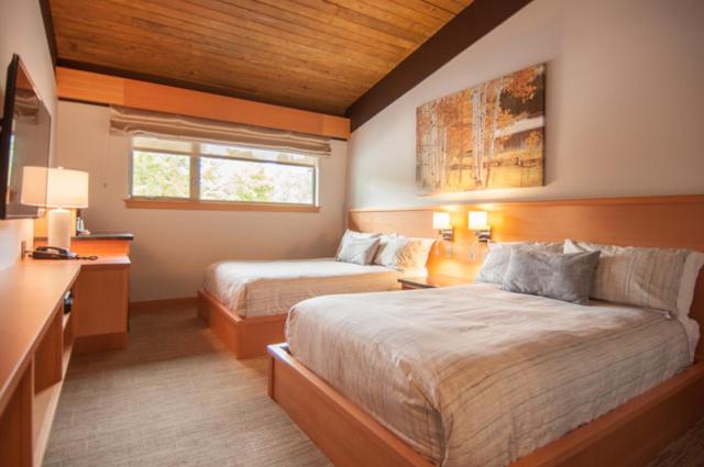 a bedroom with two beds and a desk and a window at Harbour House Hotel in Ganges