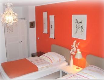 een slaapkamer met een oranje muur en een bed bij CityMinis in Düsseldorf
