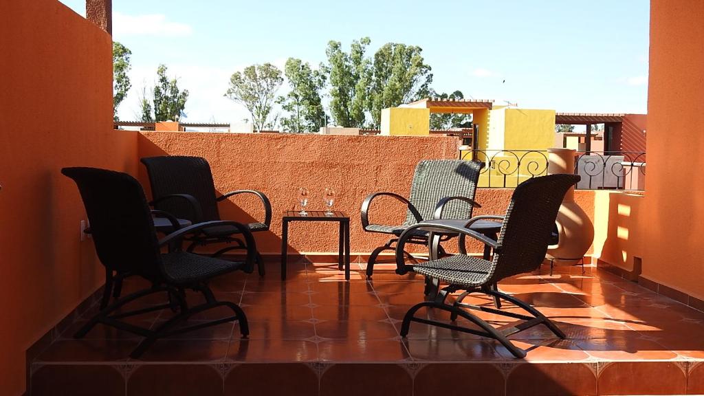 a group of chairs and tables on a balcony at La Casa de Los Milagros in San Miguel de Allende