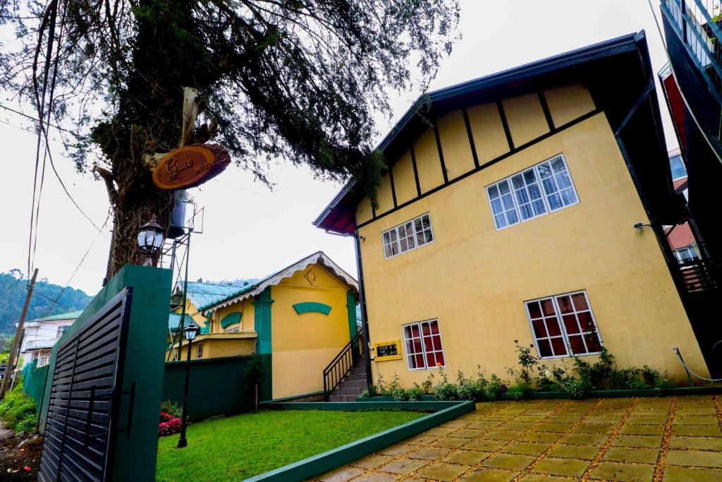 a house with a tree in front of it at Grace in Nuwara Eliya