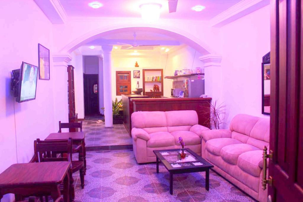 a living room with pink couches and a table at Dream Villa Galle Fort in Galle