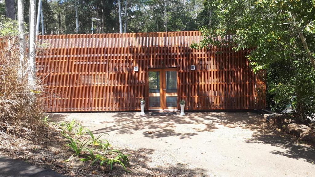 a building with a wooden door and a fence at Stay @ The Cube in Montville