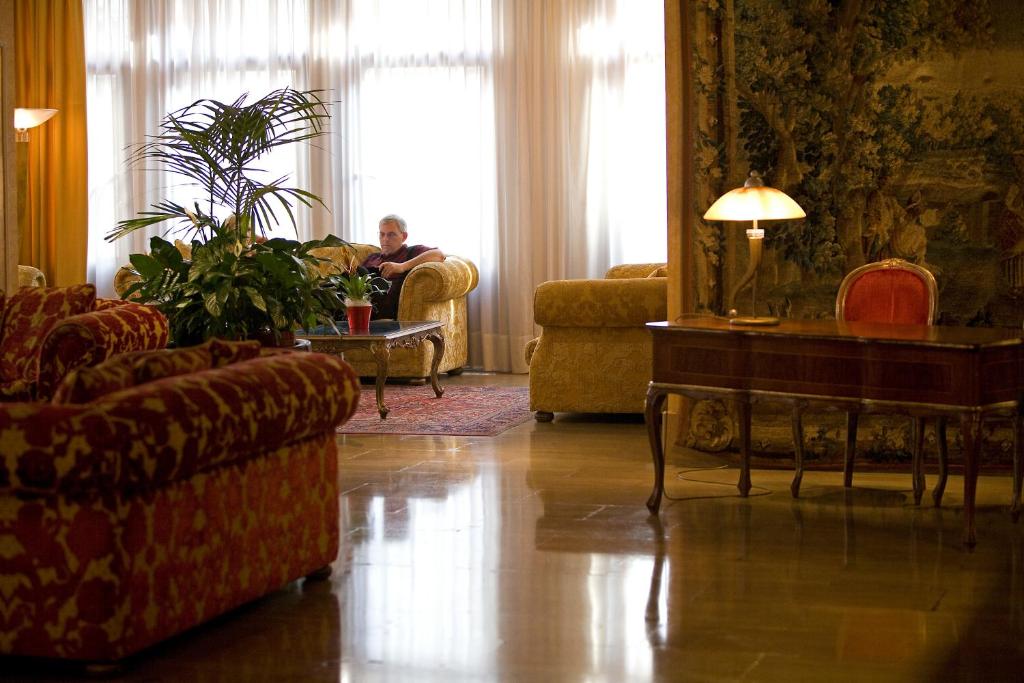 a man sitting in a chair in a living room at Hotel Principe in Venice