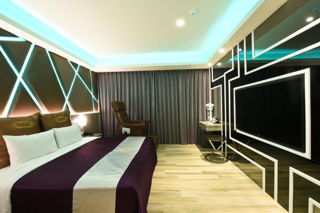 a bedroom with a bed and a flat screen tv at ZC Motel in Taoyuan