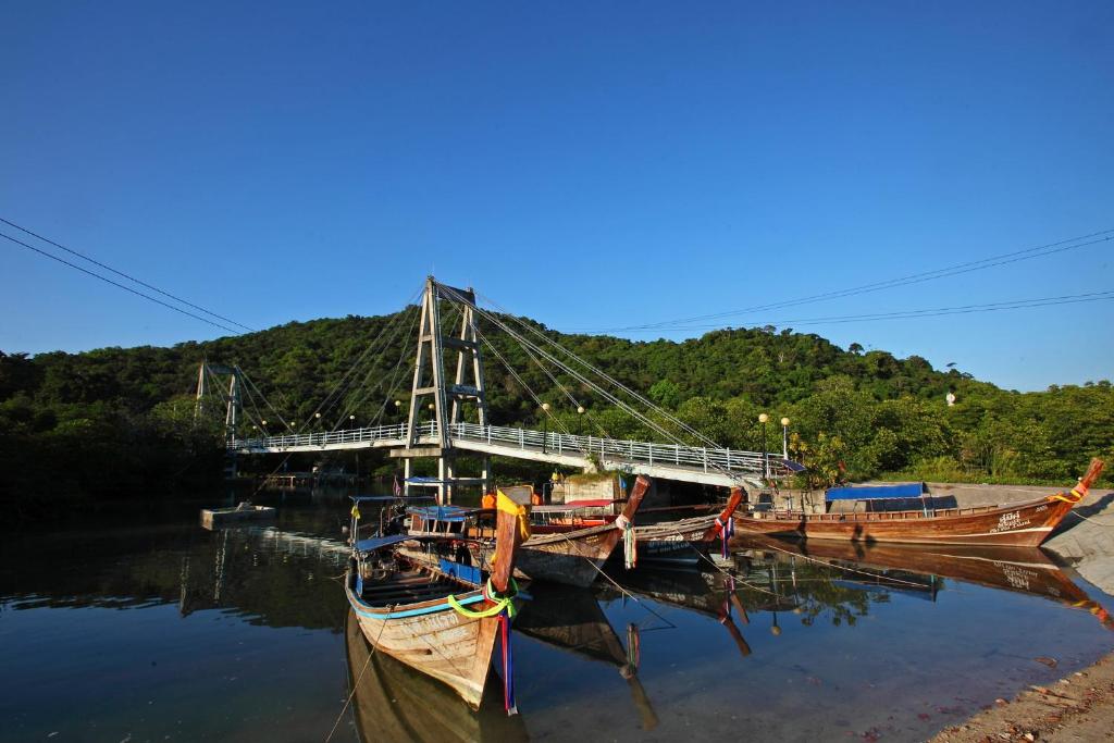 two boats are docked in the water near a bridge at PP Red Tuna Hut in Phi Phi Don