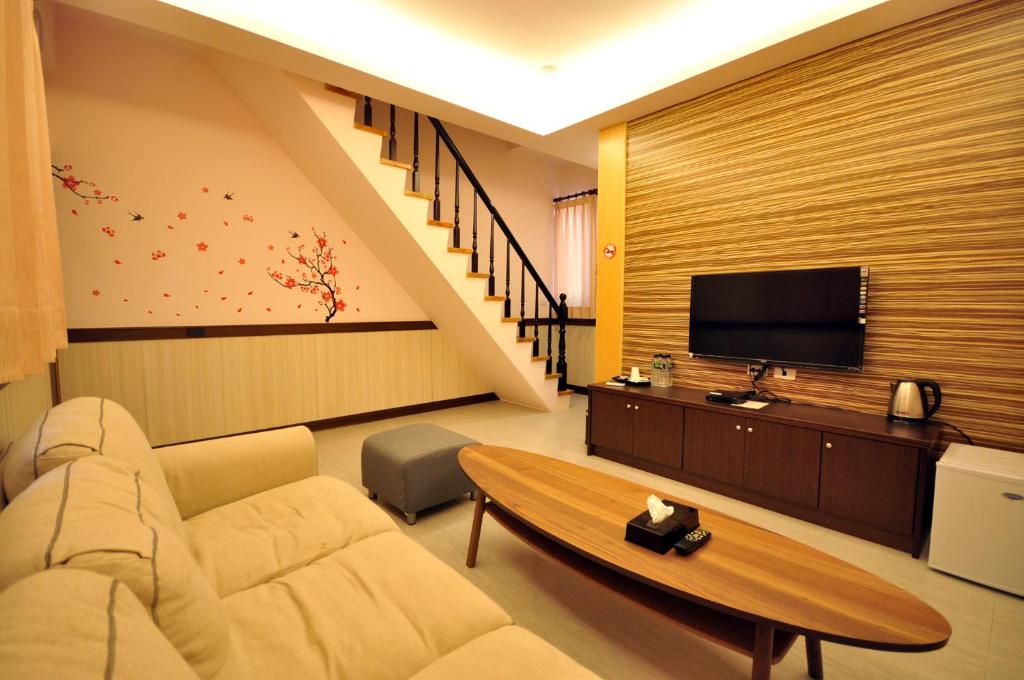 a living room with a couch and a tv at Seasons Homestay in Xiaoliuqiu