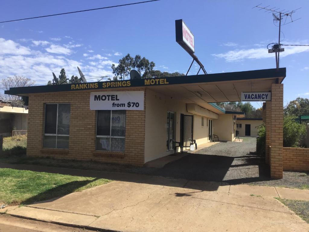 un viejo edificio de ladrillo con un cartel. en Rankins Springs Motel en Rankins Springs