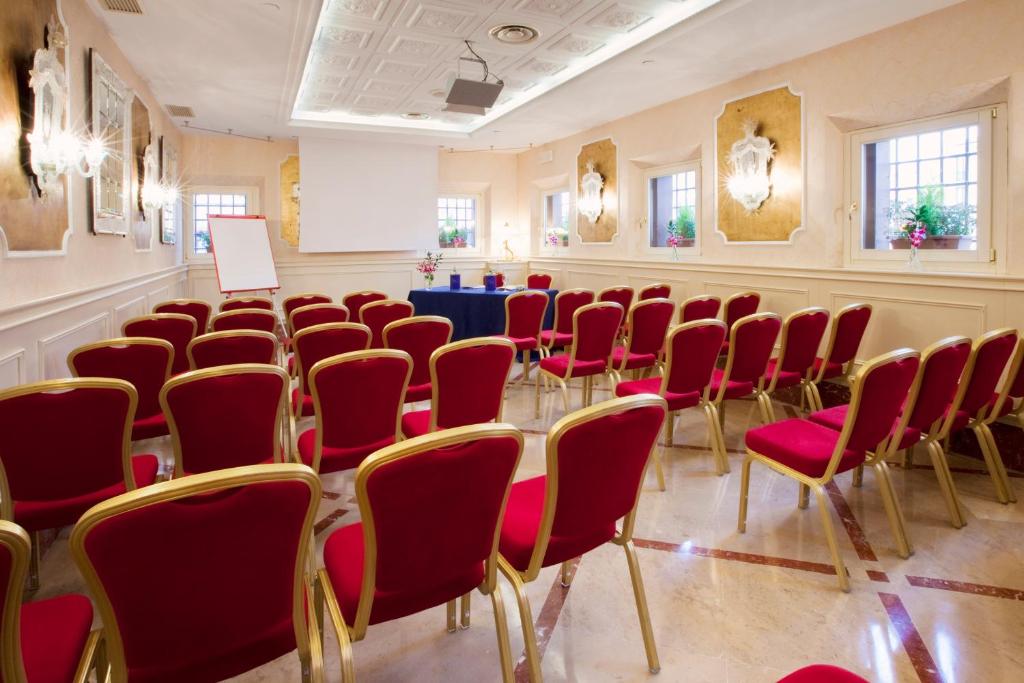 a conference room with red chairs and a table at Hotel Principe in Venice