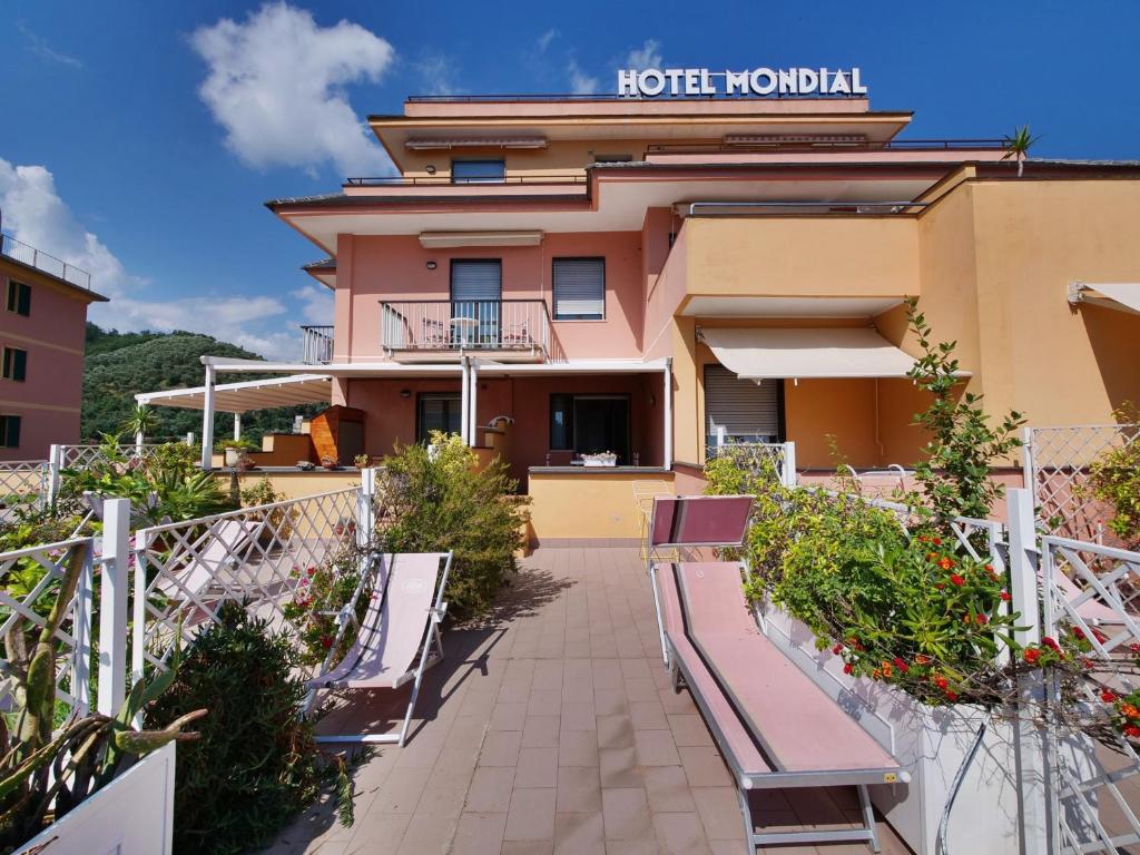 ein Hotel mit Bänken vor einem Gebäude in der Unterkunft Hotel Residence Mondial in Moneglia