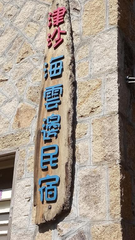 una señal en el lateral de un edificio de ladrillo en Jinsha Sea Cloud B&B, en Nangan
