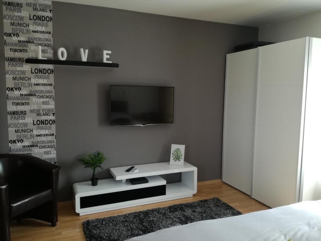 a bedroom with a tv and a white cabinet at Csabai Apartman in Bük