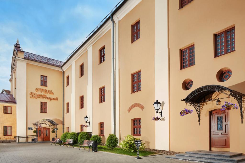 a large building with benches in a courtyard at Hotel Monastyrski Minsk City Centre in Minsk