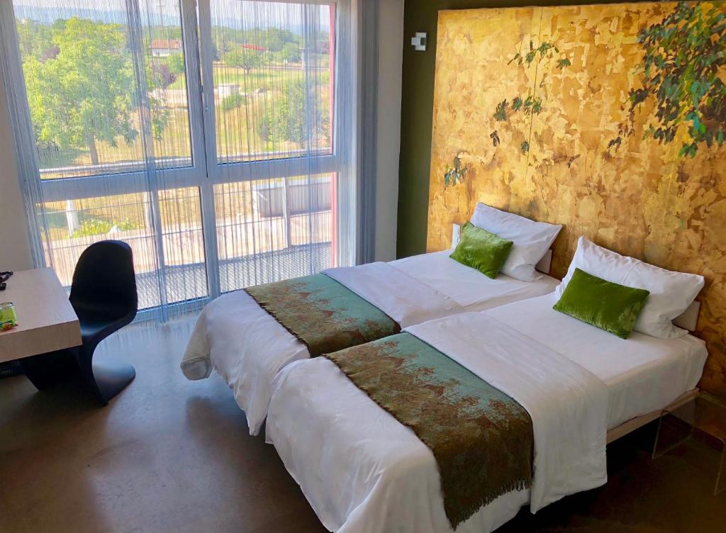 ein Schlafzimmer mit einem großen Bett und einem großen Fenster in der Unterkunft Hotel Schlafstadt in Eimeldingen