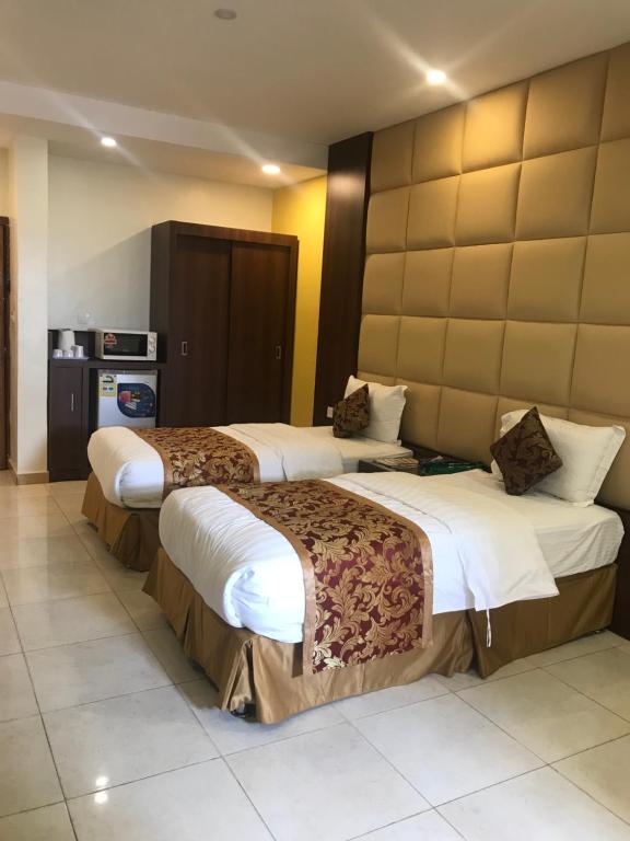 a hotel room with two beds in a room at تاج الخليج للشقق المخدومة in Dammam