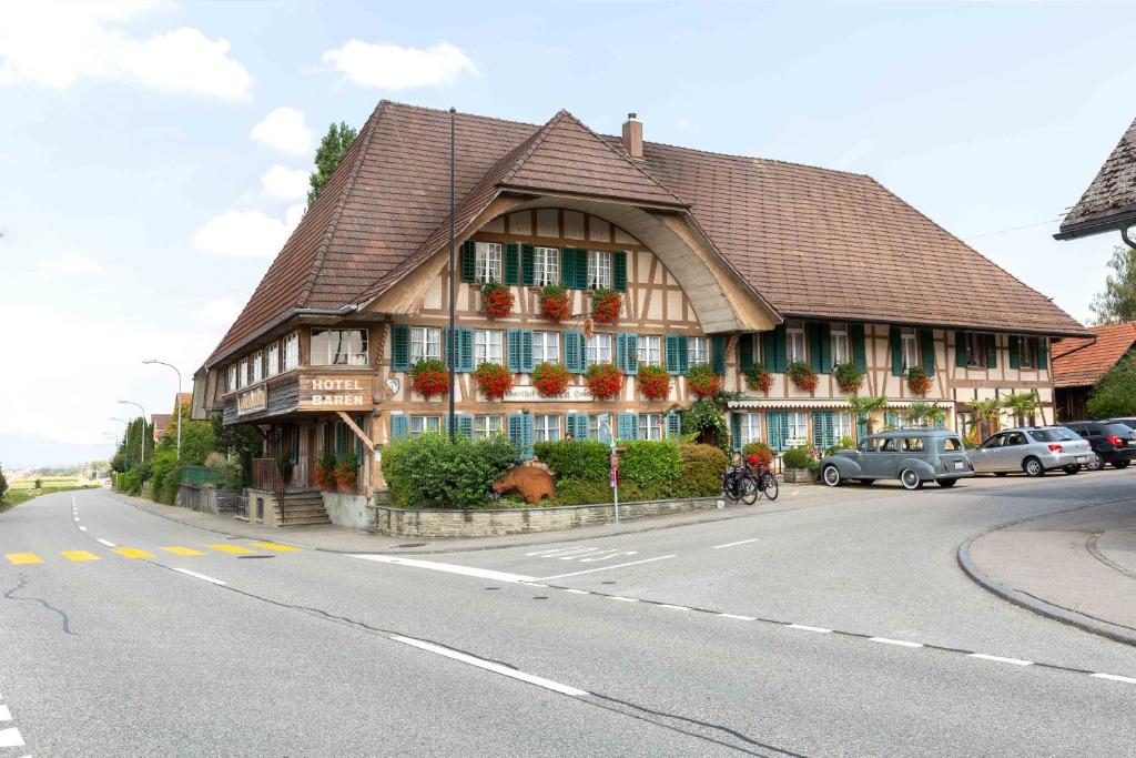 ein großes Holzgebäude an der Straßenseite in der Unterkunft Landgasthof Bären in Madiswil